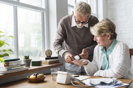 elderly couple taking medication pills