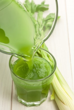 Green vegetable juice being poured into a glass