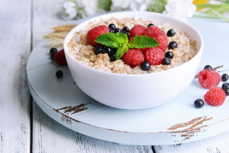A bowl of oatmeal topped with blueberries and raspberries